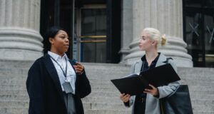 elegant-diverse-female-business-partners-with-documents-talking-on-street